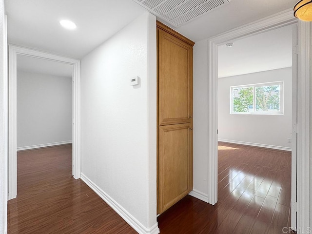 hall featuring baseboards, visible vents, recessed lighting, and dark wood-type flooring