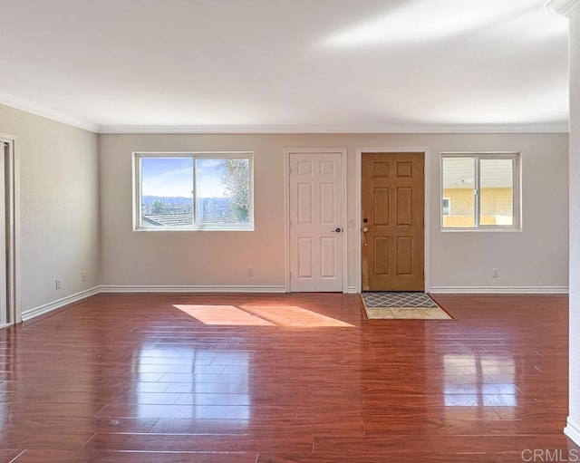 interior space featuring baseboards, ornamental molding, and wood finished floors