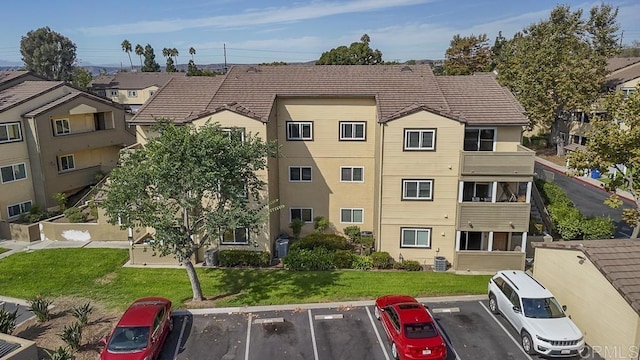 view of building exterior with a residential view and uncovered parking