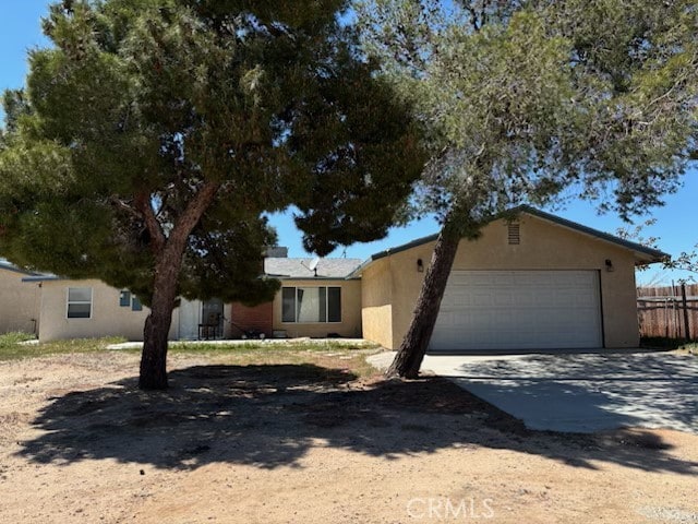 single story home with fence, an attached garage, stucco siding, and concrete driveway