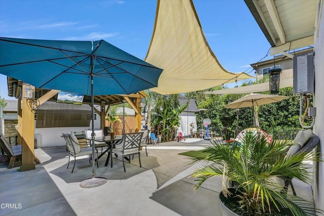 view of patio featuring outdoor dining space and fence