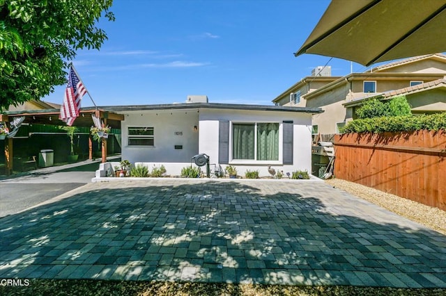 view of front of property with fence and stucco siding