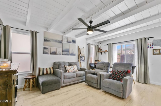 living area featuring baseboards, light wood-style flooring, a ceiling fan, beam ceiling, and wood ceiling