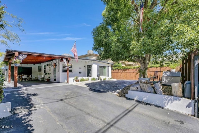 view of front of home featuring stucco siding and fence