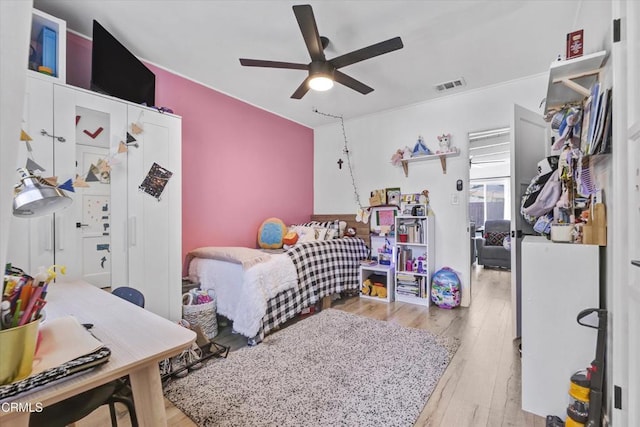 bedroom with wood-type flooring, visible vents, and a ceiling fan