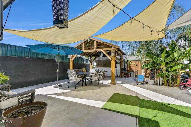 view of patio featuring a gazebo, outdoor dining area, and a fenced backyard