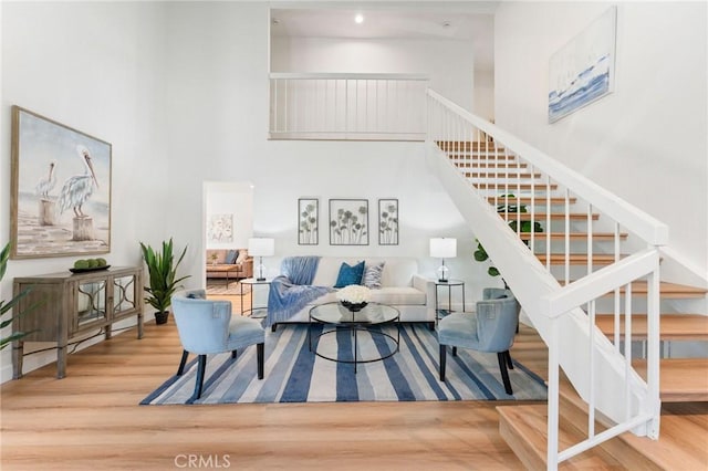 43 Ashbrook, Irvine, CA 92604 - living room featuring stairway, a towering ceiling, and wood finished floors