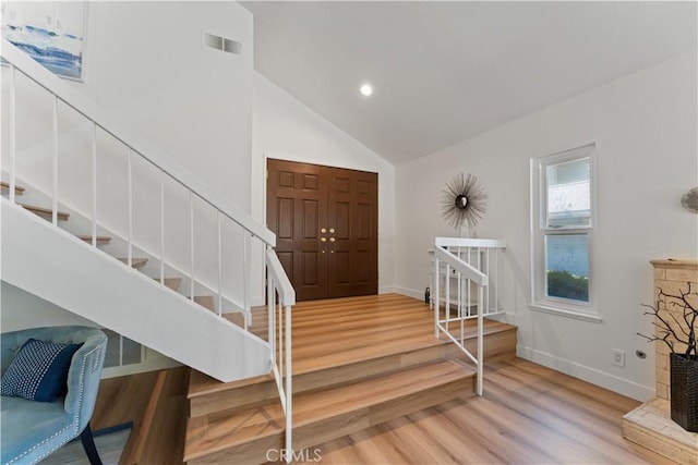 43 Ashbrook, Irvine, CA 92604 - foyer entrance with visible vents, baseboards, light wood finished floors, stairs, and high vaulted ceiling