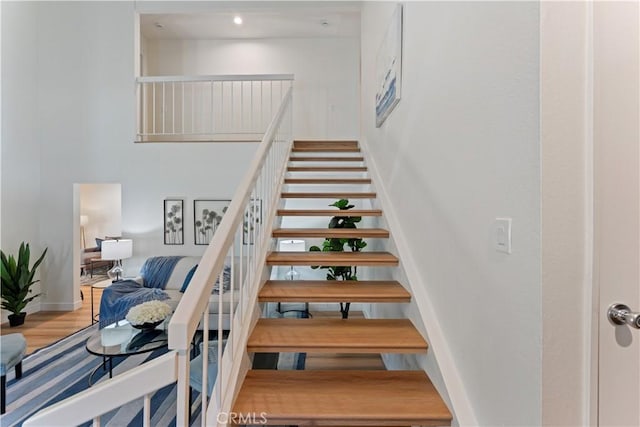 43 Ashbrook, Irvine, CA 92604 - stairway featuring baseboards, a high ceiling, and wood finished floors