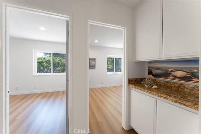 43 Ashbrook, Irvine, CA 92604 - kitchen with light wood-style flooring, white cabinets, plenty of natural light, and dark stone counters