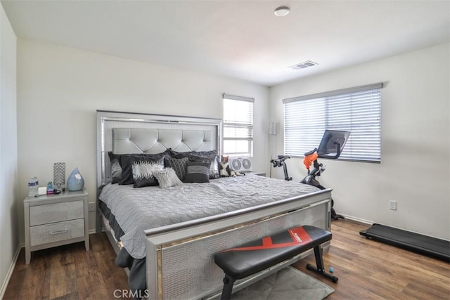bedroom featuring visible vents, baseboards, and wood finished floors