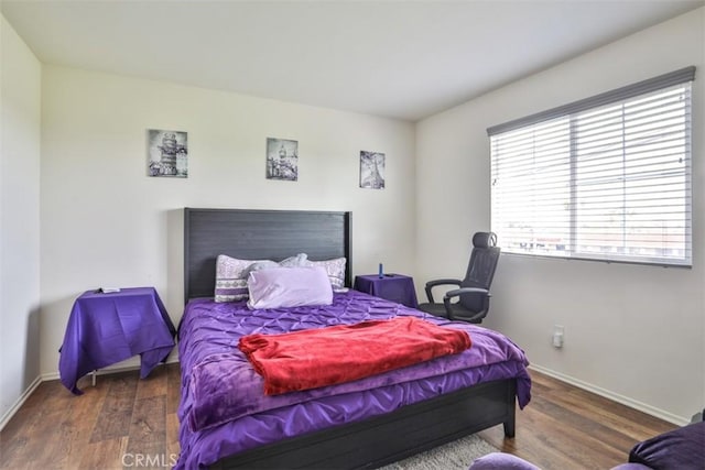 bedroom featuring baseboards and wood finished floors