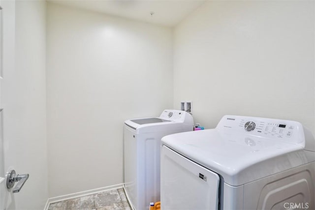 laundry area with baseboards, separate washer and dryer, and laundry area