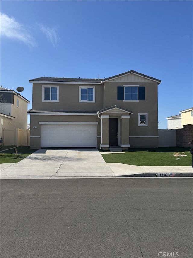 view of front facade featuring a front yard, a garage, concrete driveway, fence, and stucco siding