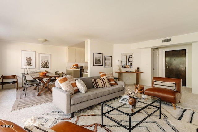 living area with visible vents and light colored carpet
