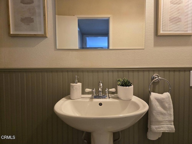 bathroom with wainscoting and a sink