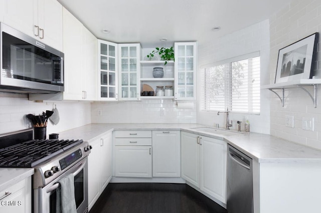 kitchen with open shelves, a sink, white cabinetry, and stainless steel appliances