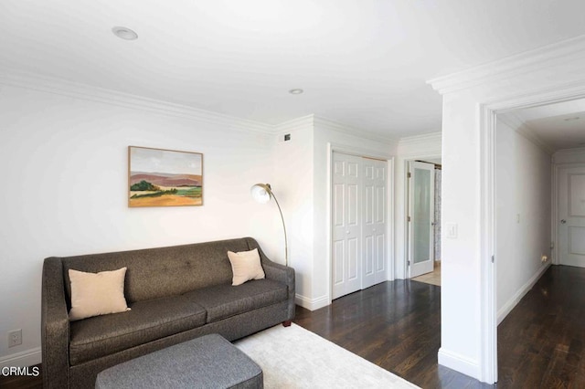 living area featuring baseboards, crown molding, and wood finished floors
