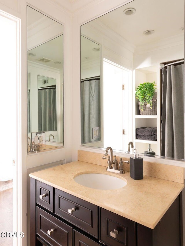full bath with crown molding, visible vents, and vanity