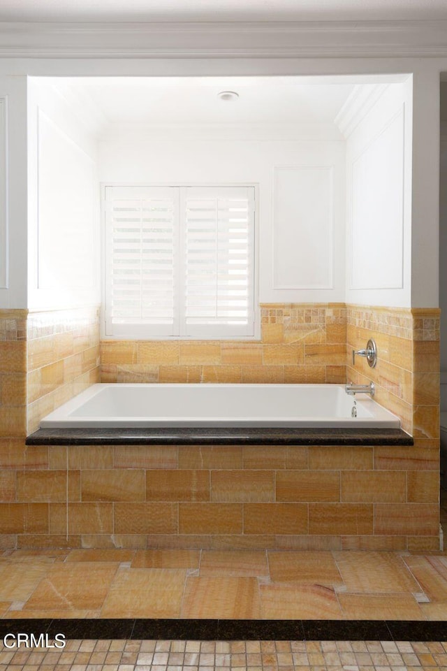 bathroom with crown molding and a garden tub