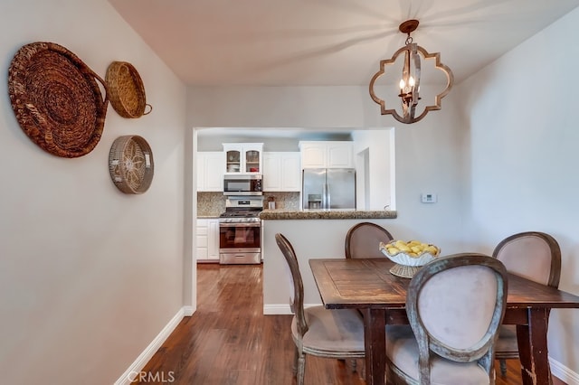 dining room featuring baseboards, a notable chandelier, and dark wood-style floors