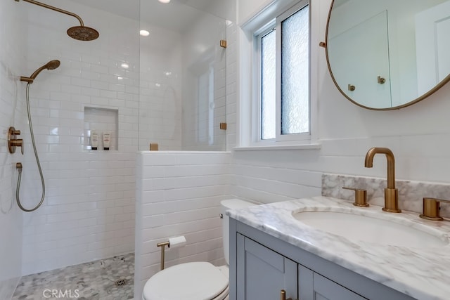 full bathroom featuring tile walls, toilet, a walk in shower, and vanity