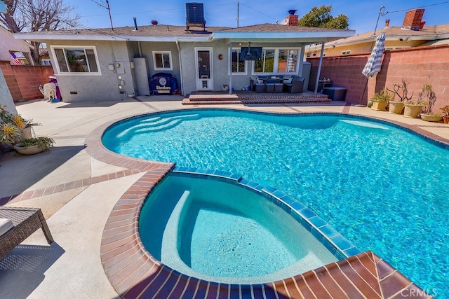 view of pool with central AC unit, a patio area, a pool with connected hot tub, and fence