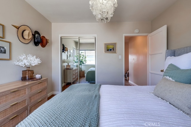 bedroom featuring a closet, baseboards, and a chandelier
