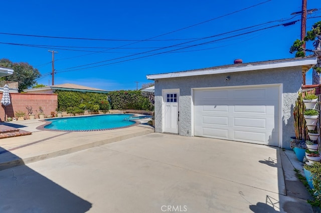 view of swimming pool with a patio, a pool with connected hot tub, an outdoor structure, and fence