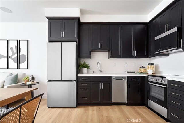 136 Hazel Dr, Rancho Mission Viejo, CA 92694 - kitchen with a sink, light wood-type flooring, dark cabinetry, and stainless steel appliances