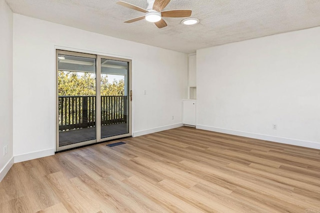 empty room featuring visible vents, light wood-type flooring, baseboards, and ceiling fan