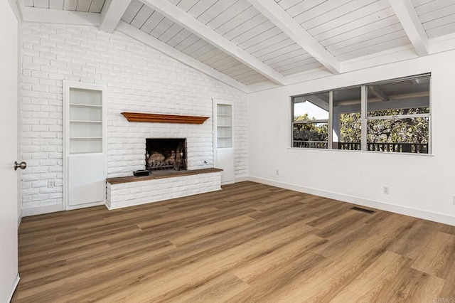 unfurnished living room featuring a fireplace, visible vents, wood finished floors, vaulted ceiling with beams, and baseboards