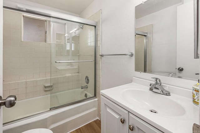 full bath with toilet, shower / bath combination with glass door, vanity, and wood finished floors
