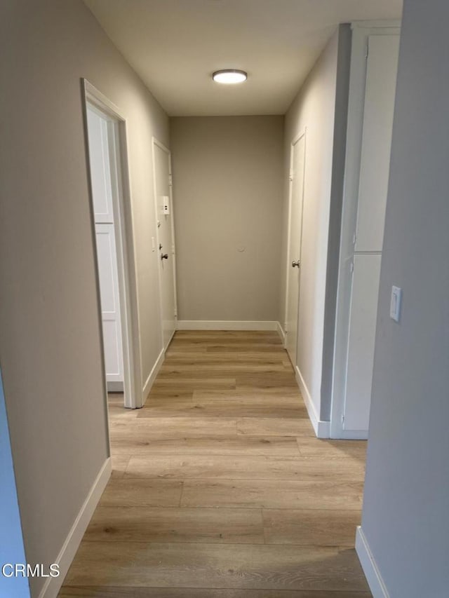 hallway with light wood-style floors and baseboards