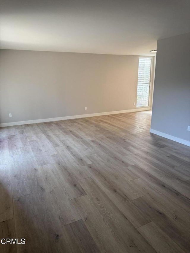 unfurnished room with baseboards and wood finished floors