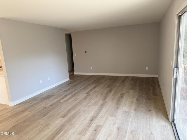 empty room with light wood-type flooring and baseboards