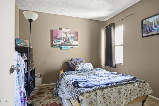 bedroom with baseboards, carpet flooring, and a textured ceiling