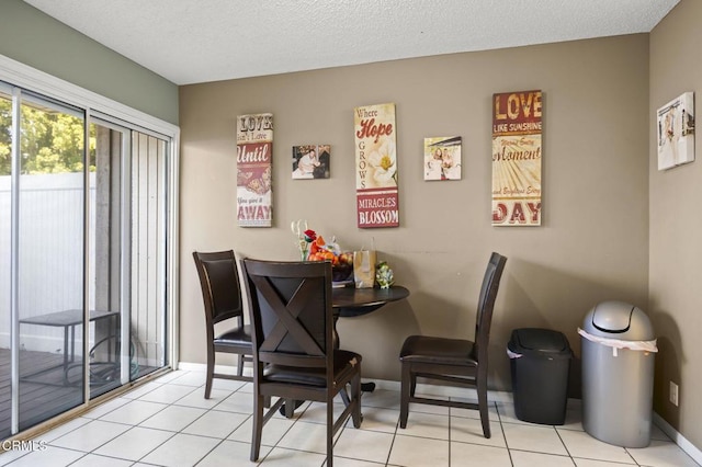 dining space with baseboards, tile patterned flooring, and a textured ceiling