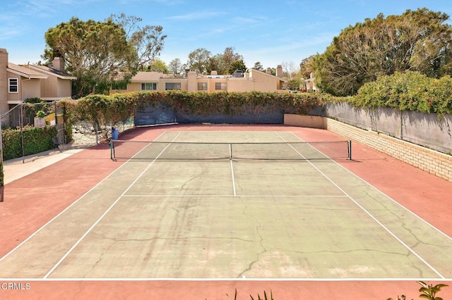view of tennis court featuring fence