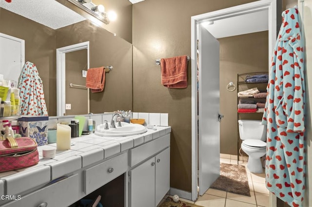 bathroom with tile patterned flooring, vanity, and toilet