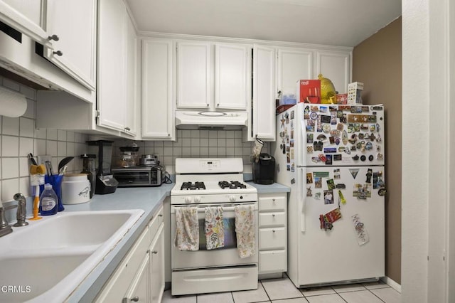kitchen with white appliances, white cabinetry, backsplash, under cabinet range hood, and a sink