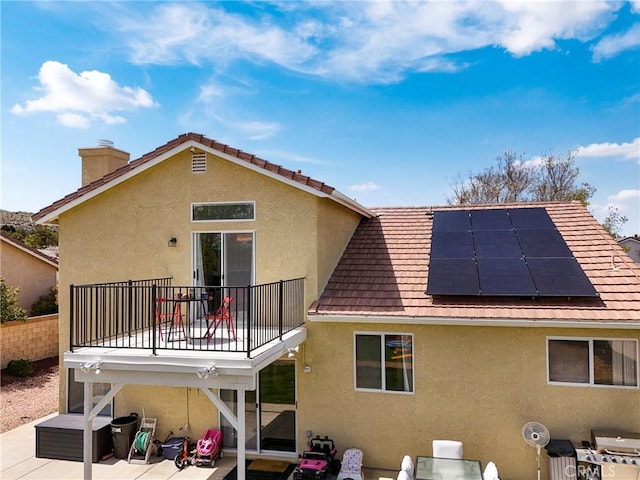 40824 Cobblestone Ct, Palmdale, CA 93551 - rear view of house featuring a patio, stucco siding, solar panels, and a chimney