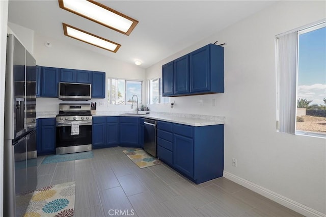40824 Cobblestone Ct, Palmdale, CA 93551 - kitchen featuring stainless steel appliances, a sink, blue cabinetry, and lofted ceiling