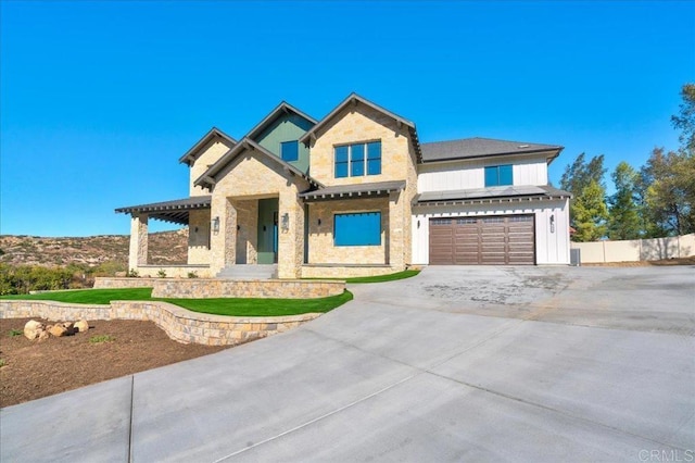 24321 Barona Mesa Rd, Ramona, CA 92065 - view of front facade featuring board and batten siding, fence, a garage, concrete driveway, and stone siding