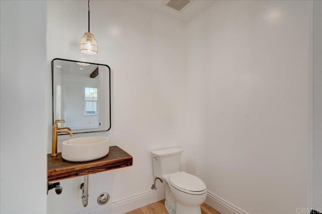 24321 Barona Mesa Rd, Ramona, CA 92065 - bathroom with toilet, baseboards, visible vents, a sink, and wood finished floors