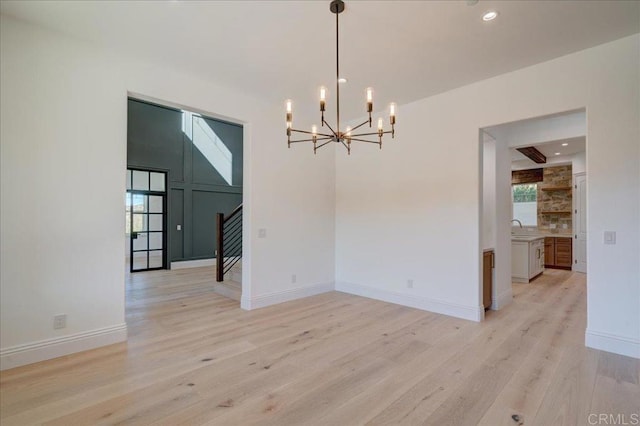 24321 Barona Mesa Rd, Ramona, CA 92065 - unfurnished dining area with baseboards, stairs, a notable chandelier, and light wood-style flooring