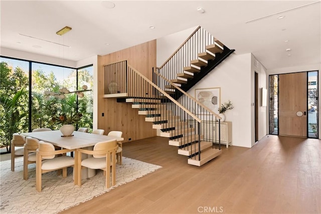 dining area featuring stairs, floor to ceiling windows, and wood finished floors