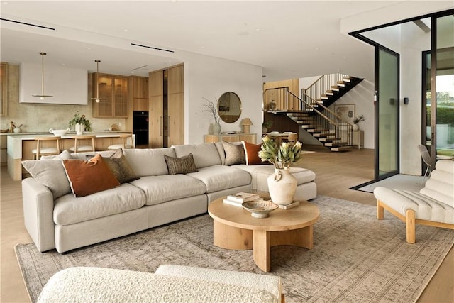 living room with stairway and light wood-style flooring