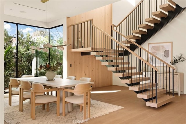 stairway featuring wood walls and wood finished floors