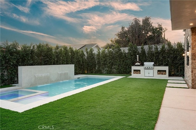 pool at dusk featuring a lawn, a fenced backyard, exterior kitchen, and an outdoor pool